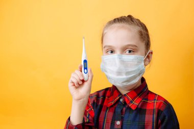 Sarı Arkaplanda Koruyucu Maskeli Küçük Bir Kız. Coronavirus 'a karşı koruma.
