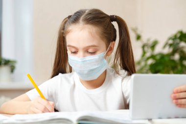Uzaktan öğrenme çevrimiçi eğitim. Liseli kız evde dijital tablet dizüstü bilgisayarla ders çalışıyor ve okul ödevi yapıyor..