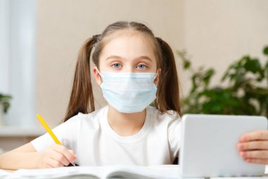 Uzaktan öğrenme çevrimiçi eğitim. Liseli kız evde dijital tablet dizüstü bilgisayarla ders çalışıyor ve okul ödevi yapıyor..