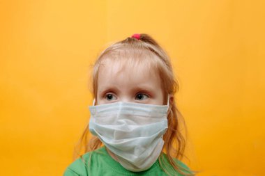 Sarı Arkaplanda Beyaz Maskeli Küçük Bir Çocuk. Coronavirus. Çocukları Salgından Korumak. Metin İçin Yer