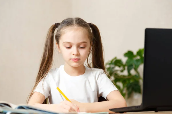 Schoolmeisje studeren huiswerk tijdens haar online les thuis, online onderwijs en online school concept, home schooler. Afstandsonderwijs of afstandsonderwijs — Stockfoto