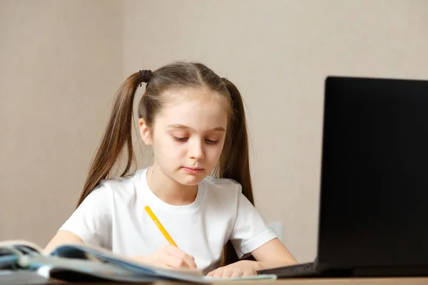 Дистанционное обучение онлайн. Школьница учится дома — стоковое фото