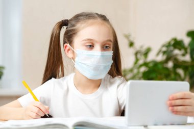 Uzaktan öğrenme çevrimiçi eğitim. Liseli kız evde dijital tablet dizüstü bilgisayarla ders çalışıyor ve okul ödevi yapıyor..