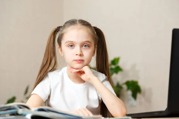 Klein meisje gebruikt laptop om thuis te leren. Het kind krijgt op afstand kennis. digitaal concept e-learning, tijdens de epidemie, quarantaine en zelfisolatie. E-learning op afstand. — Stockfoto