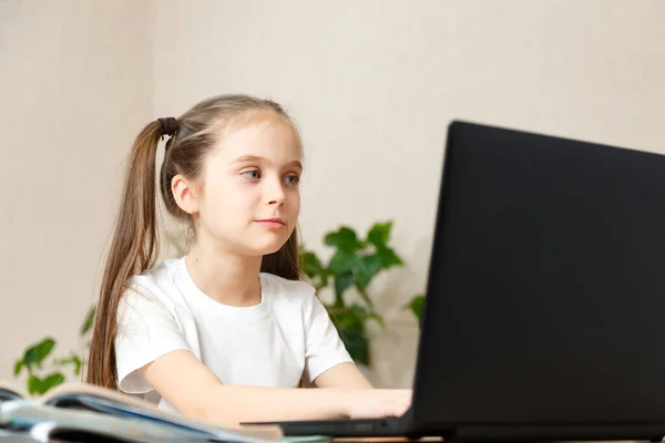 Mooi weinig school meisje werken thuis in haar kamer met een laptop en klasse notities studeren in een — Stockfoto