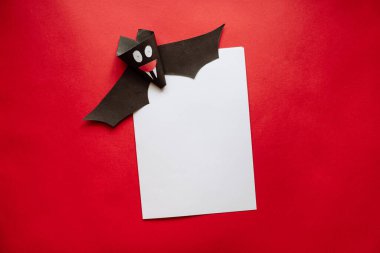 Kızıl Arkaplanda Kağıttan Yapılan Komik Cadılar Bayramı Yarasası. Cadılar Bayramı 'nda kartpostal.