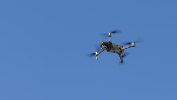 Заводоуковск, Россия, 9 мая 2020 года: "I Mavic" - современный квадрокоптер-беспилотник RC с камерой, летающей на ясном солнечном небе на голубом фоне — стоковое видео