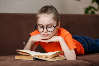 İlginç bir bölüm. Gözlüklü güzel beyaz kız evde bir koltukta uzanmış kitap okuyor..