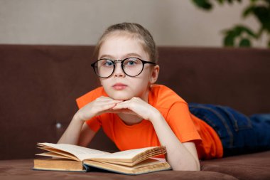 İlginç bir bölüm. Gözlüklü güzel beyaz kız evde bir koltukta uzanmış kitap okuyor..