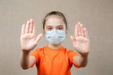 Korunmak için maske takan küçük kız. Dur işareti gösteriliyor. Virüsü ve Salgın Hastalıkları Durdurun. Coronavirus Covid-19. Evde Kal Güvenli Konsept. Seçici Odaklanma
