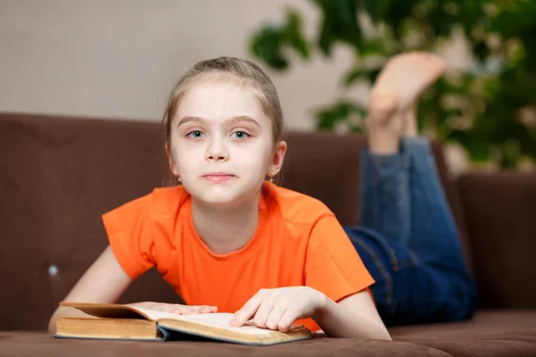 Linda Niña Caucásica Leyendo Libro Mientras Yacía Sofá Casa Durante — Foto de Stock