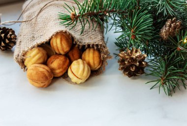  İçinde krema olan iki kabuktan yapılmış fındık şeklinde çörekler olan çuvalı aç. Beyaz arkaplanda çerezler