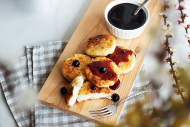 Sabah kahvaltısı var. Ahşap arka planda reçelli süzme peynirli krep. Rus, Ukrayna mutfağı.