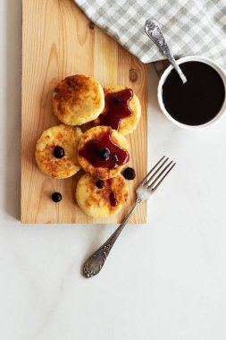 Sabah kahvaltısı var. Ahşap arka planda reçelli süzme peynirli krep. Rus, Ukrayna mutfağı.