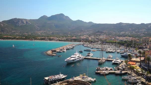 Historische panden in de oude stad Calvi met turkoois — Stockvideo