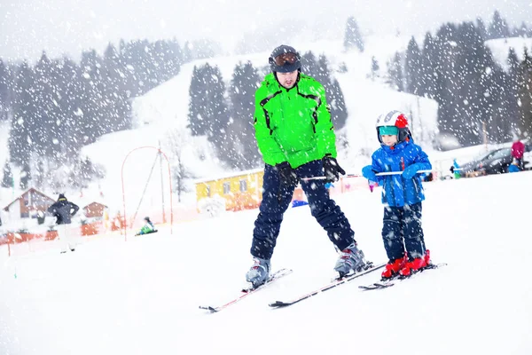 Glad liten pojke att lära sig åka skidor med sin far i schweiziska Alperna — Stockfoto