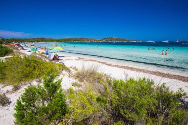 Cala Brandinchi, Sardunya - Ağustos 2017 - Cala Brandinchi Beach'te Isola Travolara ile arka plan, kırmızı taşlar ve gök mavisi berrak su, Sardunya, İtalya.