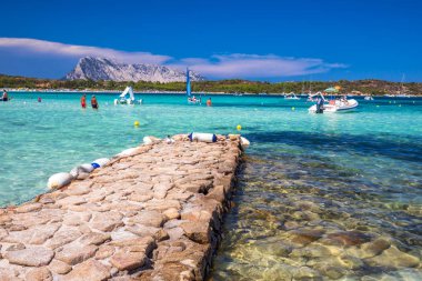 Cala Brandinchi, Sardunya - Ağustos 2017 - Cala Brandinchi Beach'te Isola Travolara ile arka plan, kırmızı taşlar ve gök mavisi berrak su, Sardunya, İtalya.