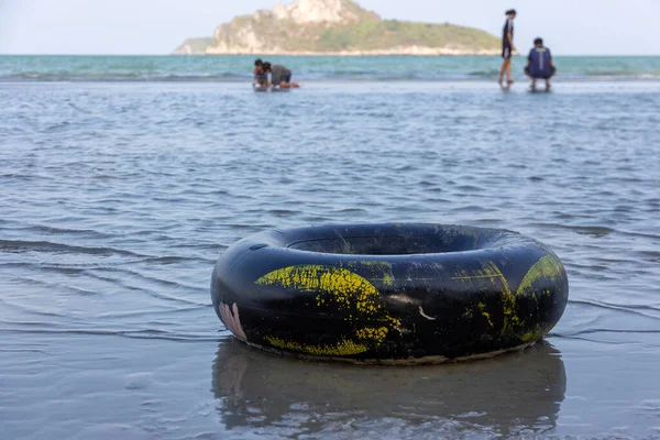 A black swim ring on a sandy ocean beach,life ring,Summer holiday and vacation concept.