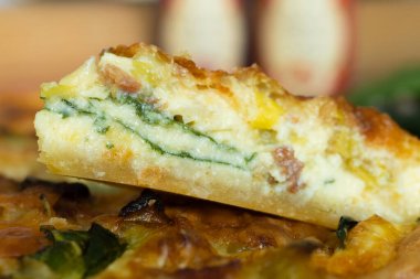 Koyu arkaplanda taze pişmiş pırasa pastırmalı ıspanaklı kiş.