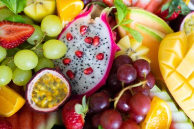 Dilimlenmiş taze tropikal meyve tabağını kapat, arka plan kullan