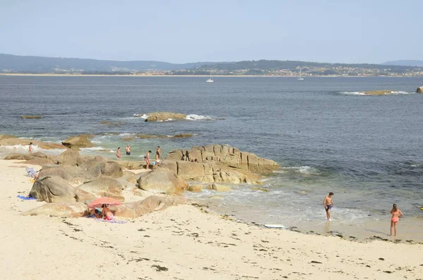 Människor på stranden i en sommardag — Stockfoto