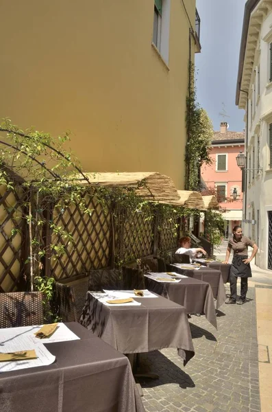 Fila de mesas de restaurante en un callejón — Foto de Stock