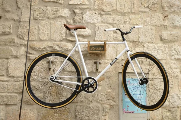 Белый велосипед на каменной стене — стоковое фото