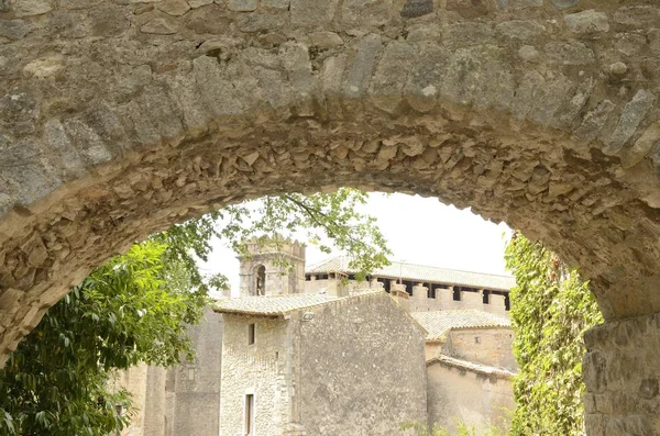 Edifici in pietra attraverso arco — Foto Stock