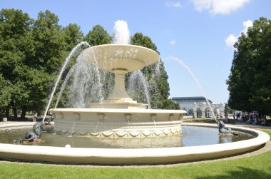 Warsaw, Poland - July 30, 2018: People surrounding  fountain in park of Warsaw, Poland.
