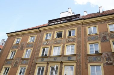 Varşova, Polonya - 30 Temmuz 2018: Polonya 'nın tarihi merkezindeki tarihi binanın cephesinde güzel tablolar.