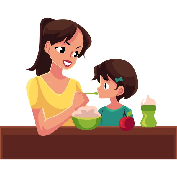 Mother spoon feeding her little daughter sitting on the floor — Stock Vector