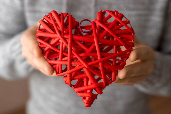 Rött flätat dekorativt hjärta i mäns händer — Stockfoto