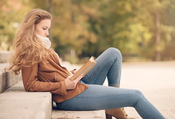 Güzel bir kadın parkta kitap okuyor. — Stok fotoğraf