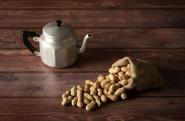 Cacahuetes en saco sobre fondo de madera — Foto de Stock