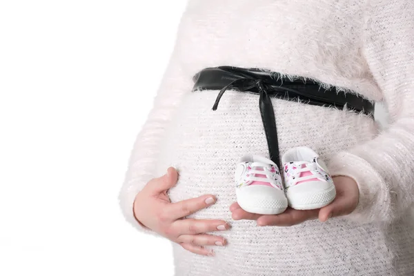 Foto de mujer embarazada sosteniendo zapatos de bebé — Foto de Stock