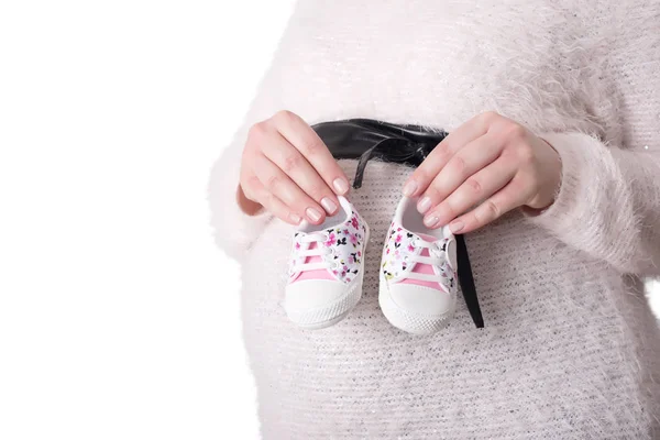 Φωτογραφία από την έγκυο γυναίκα, κρατώντας τα παπούτσια μωρών — Φωτογραφία Αρχείου
