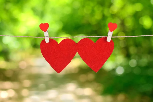 Rött hjärta form hängande, över naturliga bakgrunden — Stockfoto