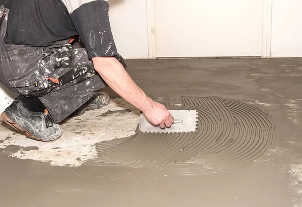 İşçi yapışkan seramik için uygulanan