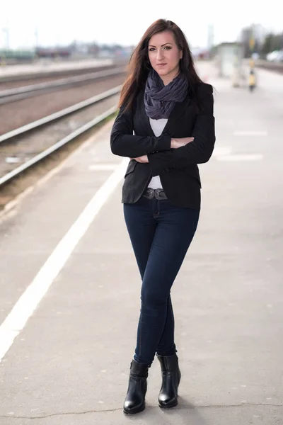 Krásná žena stojí u vlakového nádraží — Stock fotografie