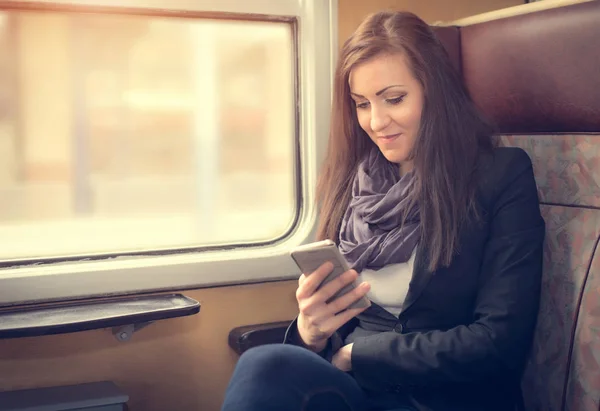 Chica viajero utilizar el teléfono en el tren — Foto de Stock