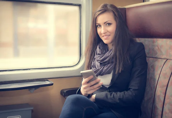 Chica viajero utilizar el teléfono en el tren — Foto de Stock