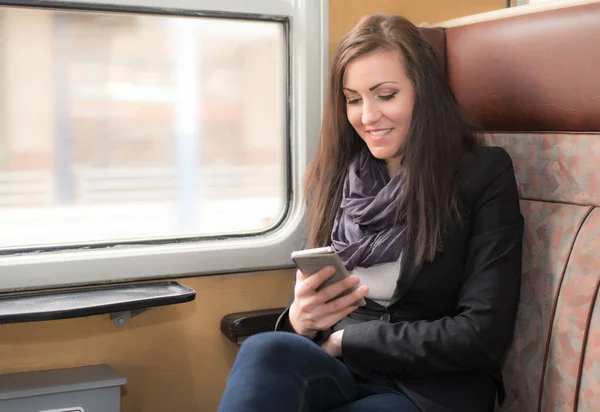 Chica viajero utilizar el teléfono en el tren — Foto de Stock