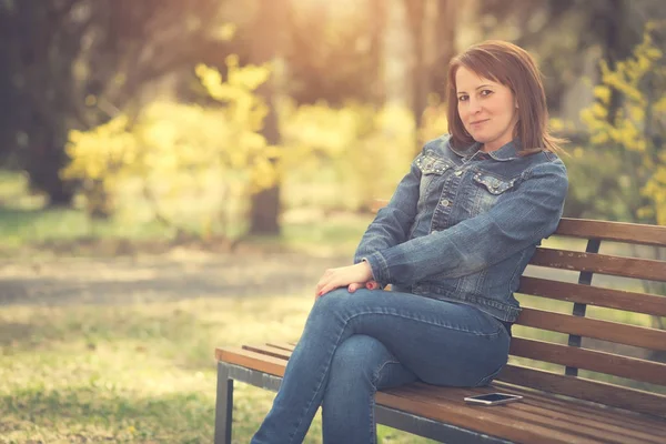 Femme mignonne assise sur le banc — Photo