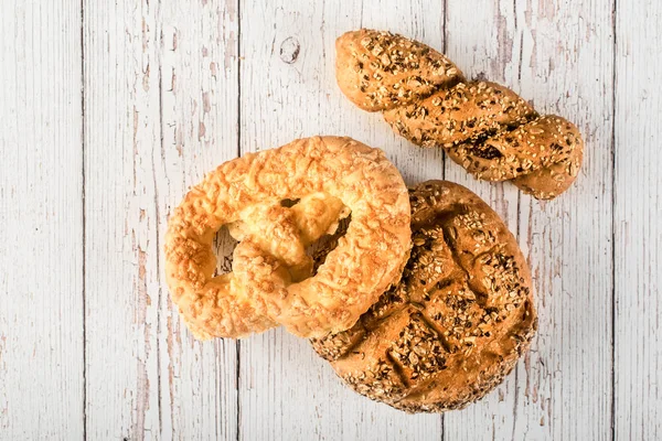 Pães seedy frescos no fundo de madeira branco — Fotografia de Stock