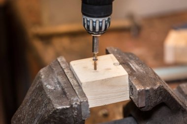 İşçi ahşap İşlenecek parçanın içine bir vida vidalama