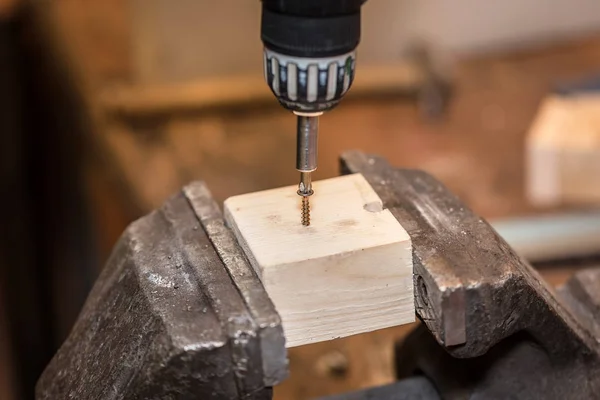 Munkavállaló csavarozásra egy csavar, fából készült munkadarabot — Stock Fotó