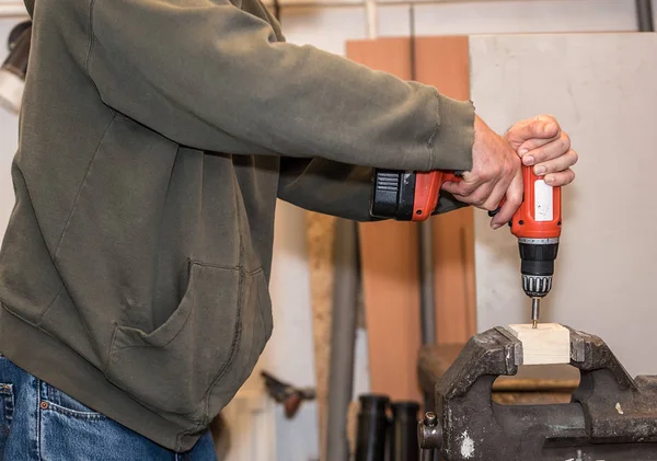 Lavoratore sta avvitando una vite in pezzo di legno — Foto Stock