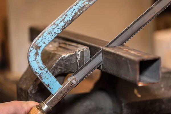Ingegnere che lavora al taglio di un metallo con sega — Foto Stock