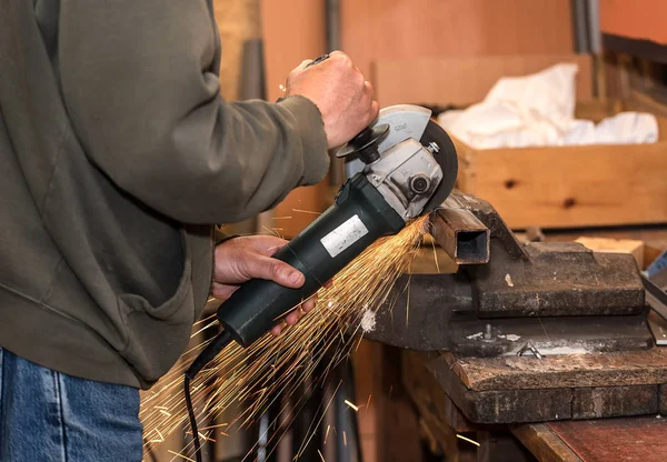 Man arbetar med elektrisk slipmaskin verktyg på stål — Stockfoto